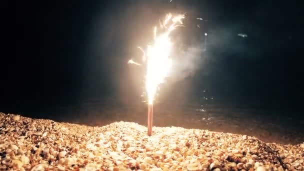 Sparkler ardiendo en la noche en la costa del mar — Vídeos de Stock