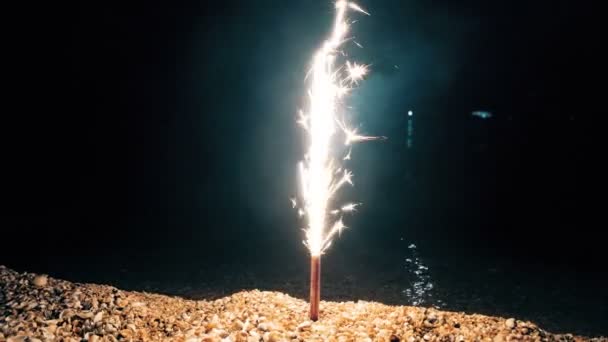 Sparkler en la costa del mar va hacia abajo — Vídeos de Stock