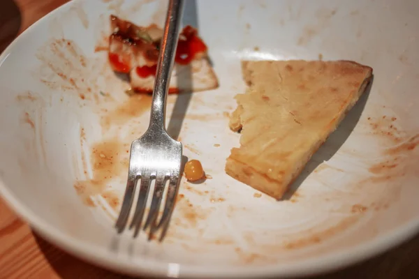 Вилка на тарелке с наполовину съеденной пиццей — стоковое фото
