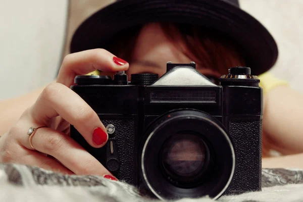 Το κορίτσι με το κόκκινο χαιρετά λήψη φωτογραφιών χρησιμοποιώντας φωτογραφική μηχανή Slr μπροστά από το πρόσωπό της, vintage χρώμα — Φωτογραφία Αρχείου