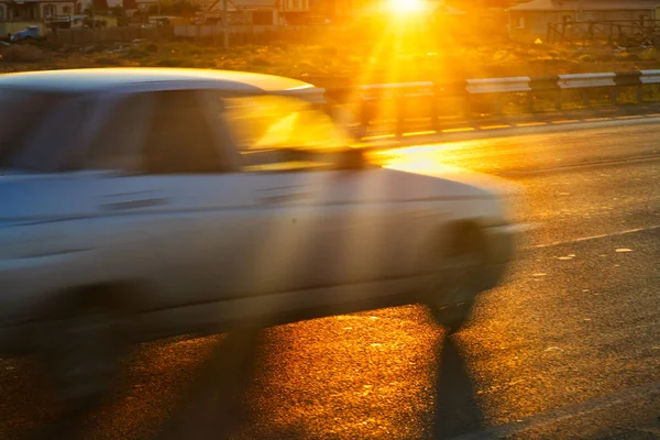 Coche de cercanías desenfocado en la carretera con destellos de sol —  Fotos de Stock