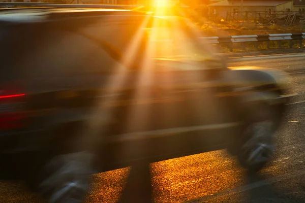 Motion desenfoque coche en la carretera con las luces del sol — Foto de Stock