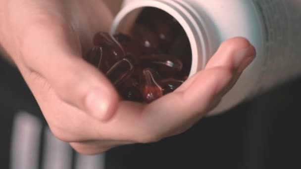 Morsen van de jongen terug in de fles voedingssupplement capsules — Stockvideo