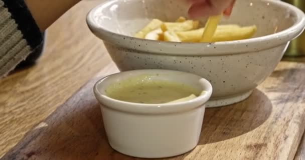 Närbild Video av en Hand om tonårspojke med pommes frites från skål som serveras på bordet — Stockvideo
