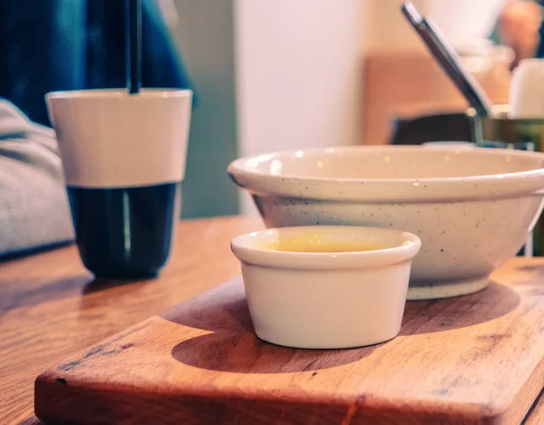 Koffie en kommen van voedsel op tafel — Stockfoto