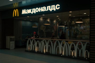 Astrakhan, Rusya Federasyonu 13 Şubat 2019: Mcdonalds alışveriş merkezi. İşareti ve Rus dilinde marka adını McDonalds fast food restoran Mağaza mcdonald altın kemerler