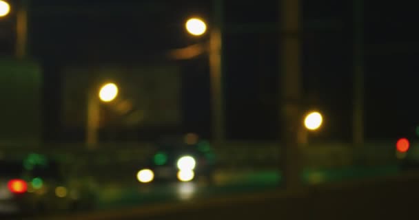 Tráfico y semáforos desenfocados por la noche. El sujeto de la filmación es borroso . — Vídeos de Stock