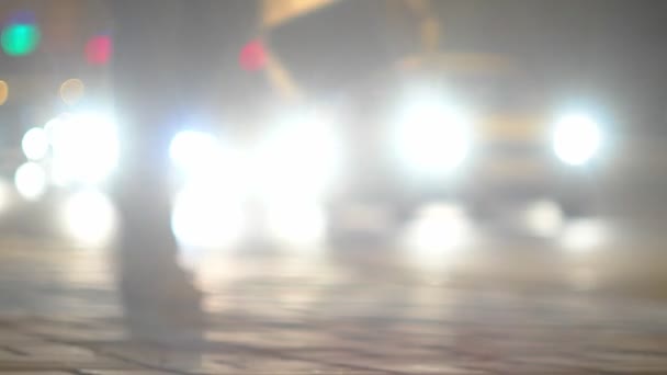 Defokussierte Autos setzen sich bei Grünlicht in Bewegung. Stadtverkehr in der Nacht — Stockvideo