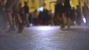 Gece sokağında dans eden çiftlerden oluşan odaksız bir grup.