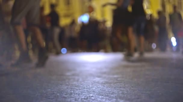 Defokussierte Gruppe junger Leute, die in der Nacht auf der Straße tanzen — Stockvideo