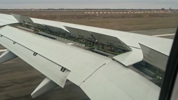 Jet Plane Landing. Passenger jet airliner landing on an airport runway with wing elevons flaps up — Stock Video