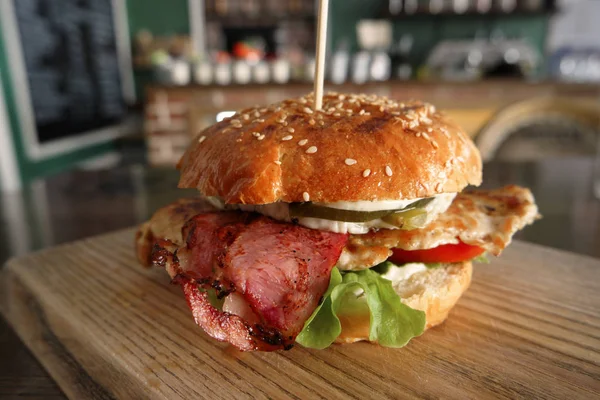 Grilovaný Burger podávané na dřevěné desce na stole v hospodě — Stock fotografie