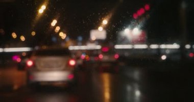 Yağmurlu gecede sınır çizgisine doğru yavaş hareket eden araçların bulanık video