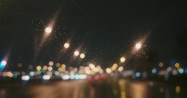 Wiele nieostrych świateł miejskich na nocnej drodze w deszczowej pogodzie — Wideo stockowe
