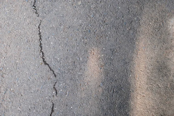 Asfalto con grieta y sombras. Antiguo camino gris para fondo o textura. Asfalto como fondo abstracto o telón de fondo con un espacio de copia — Foto de Stock