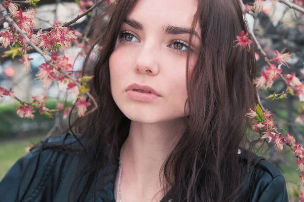 Menina posando no jardim perto de árvore de cereja florescendo — Fotografia de Stock