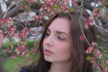 Çiçek açan kiraz ağacı dallarında kızın romantik portresi. Bahar Kız