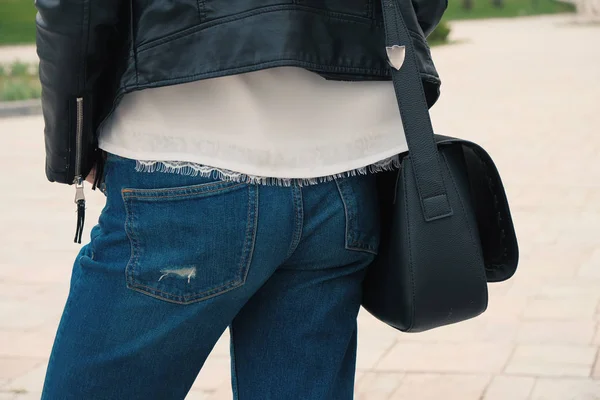 Молодая женщина позирует с черной сумочкой вид сзади — стоковое фото