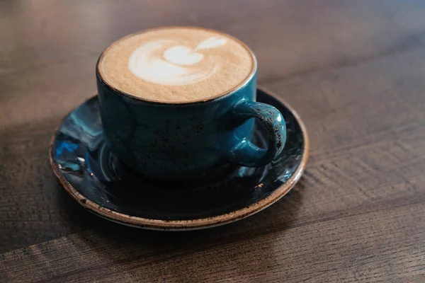 Side view of Coffee cup with perfect latte art on foam on tabletop — Stock Photo, Image