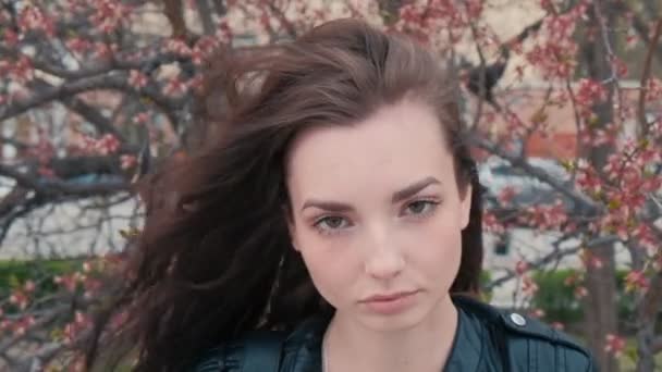 Brunette fille posant avec dépression vierge en face de cerisier en fleur — Video