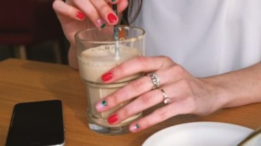 Esmer kız elleri kantinde kahve içiyor