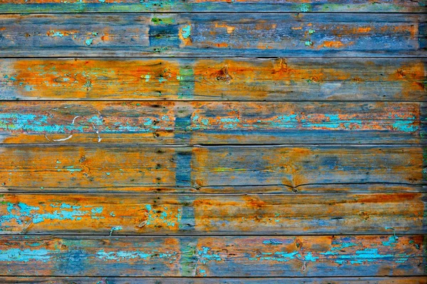 Nagyon régi fa kerítés a vidéki területen lábnyomok a kék festék és élénk narancssárga színű fa felülete — Stock Fotó