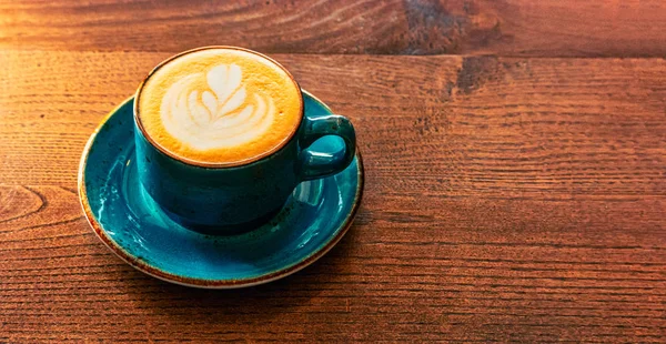 Green color coffee cup full of cappuccino coffee stands on the tabletop — Stock Photo, Image