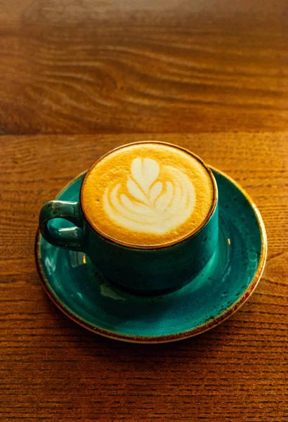 Imagem vertical da xícara de café verde cheio de café cappuccino fica na mesa, inage com um monte de espaço de cópia . — Fotografia de Stock