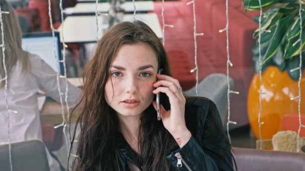 Junge Studentin telefoniert per Smartphone im Café — Stockvideo
