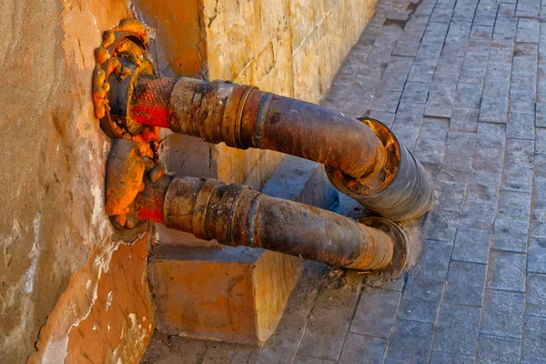Dvě teplé vodovodní trubky napojený na stěnu — Stock fotografie