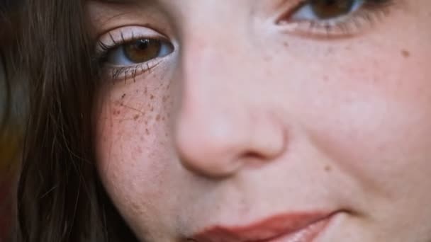 Belle femme visage avec des taches de rousseur cheveux bruns, les yeux verts en gros plan extrême — Video