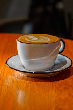 Dikey görüntü Fincan cappuccino pn kahverengi renkli masa copyspace ile vurdu