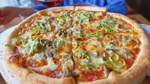 Hij serveerde smakelijke pizza op tafel. Camera vooruit, real time, close-up — Stockvideo