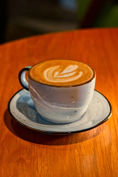 Šálek cappuccino na hnědém dřevěném stole s copyspace — Stock fotografie