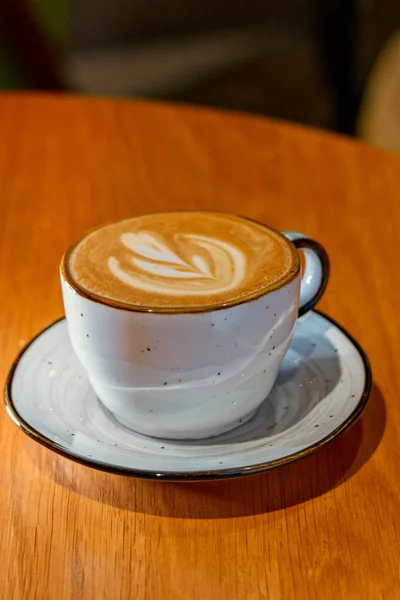 Keramický šálek cappuccino podávaný na dřevěném stole s copyspace — Stock fotografie