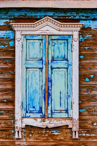 Geschnitztes Holzfenster mit abblätternden Farben — Stockfoto