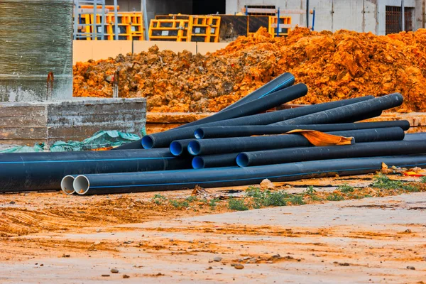 Tubos de água de plástico deitado no chão do local de construção com copyspace — Fotografia de Stock