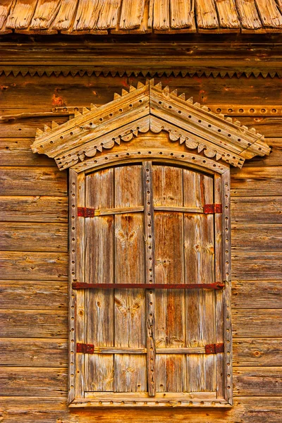 Traditional russian wooden window with closed shatters in warm tones — Stock Photo, Image