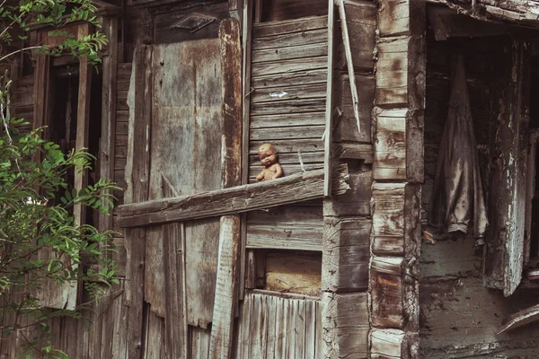 Old destroyed slum house with spooky doll — Stock Photo, Image