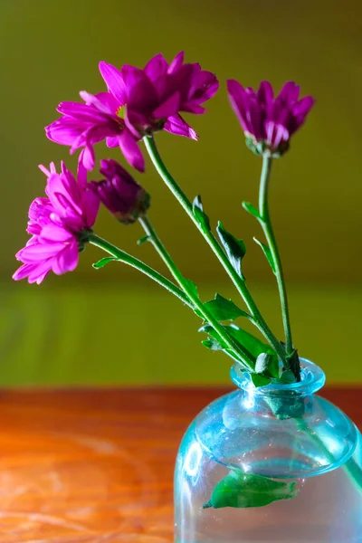 Zbliżenie wiosennych kwiatów w niebieskiej szklanej butelce na polerowanej tabeli z Copyspace. — Zdjęcie stockowe