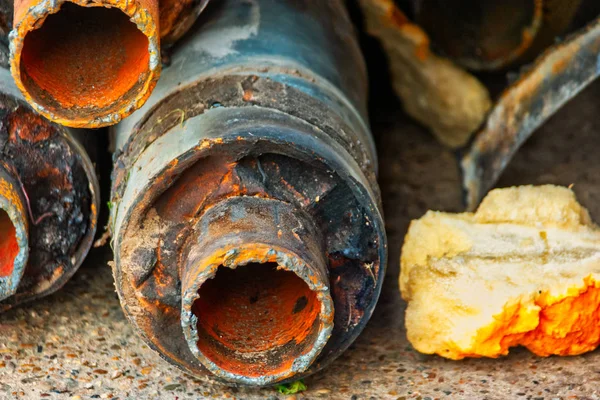 Fines de tuberías de agua caliente gastadas en la pila cerca de la pared — Foto de Stock