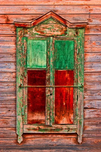 Fenêtre en bois altérée dans les bidonvilles peints en vert et rouge — Photo