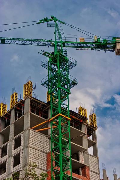 Construction site of apartment building with Crane of green color and copy-space on cloudy sky — Stock Photo, Image