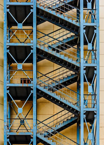 Edificio de apartamentos de hormigón alto con escaleras de escape de incendios externas repetidas con barandillas metálicas —  Fotos de Stock