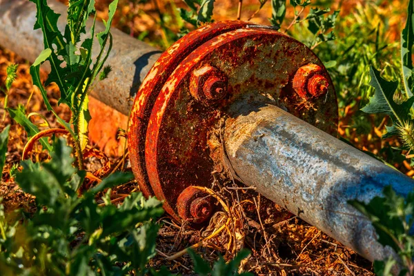 Närbild av rostiga rör anslutning. Gamla och rostiga, förfallna rör installeras på gräset i trädgården — Stockfoto
