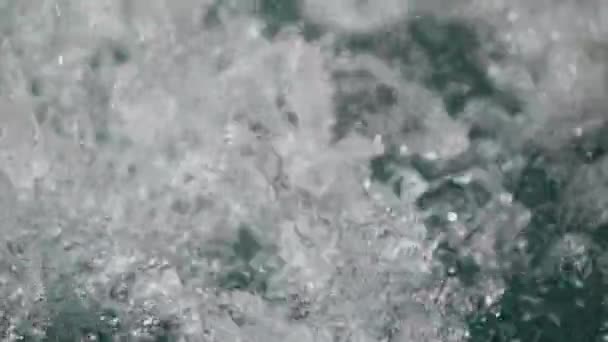 Water druppels spatten over wateroppervlak — Stockvideo