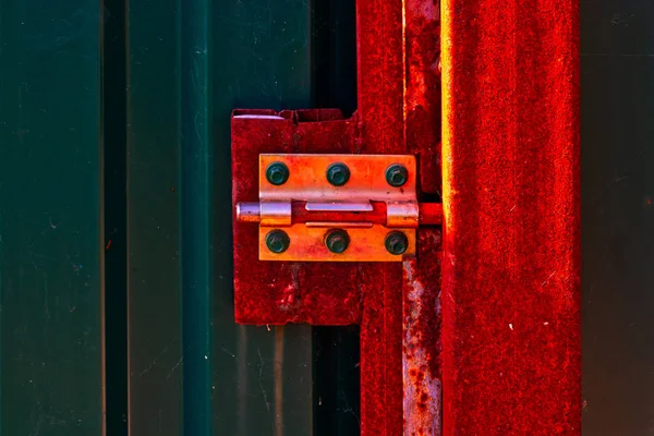 Rusty door hinge on metal door.