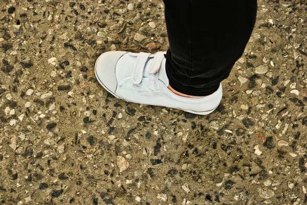 Selfie witte schoen op beton. Close-up vrouw dragen witte sneakers en zwarte jeans op concrete weg achtergrond. — Stockfoto