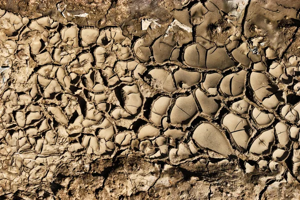 Brown sprucken mark från ovan, Cray jord, lera spricka. Sprickor på ytan av jorden ändras genom krympning av lera på grund av torka tillstånd — Stockfoto