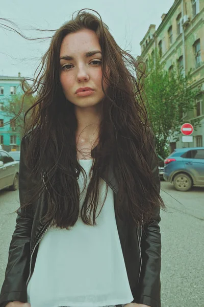 Dışarıda rüzgarlı saçlarla poz veren barışçıl görünümlü bir kız, geniş açılı akıllı telefon lensi taklidi dikey görüntü. — Stok fotoğraf